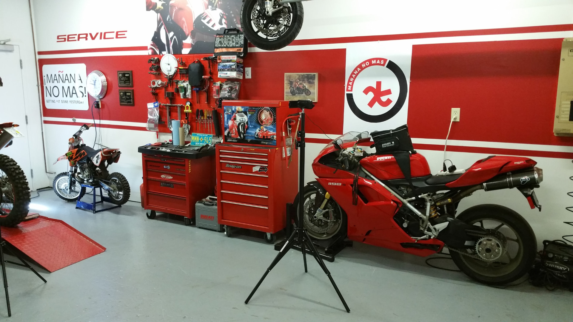 A Ducati service bay with Mañana No Más branding on the wall
